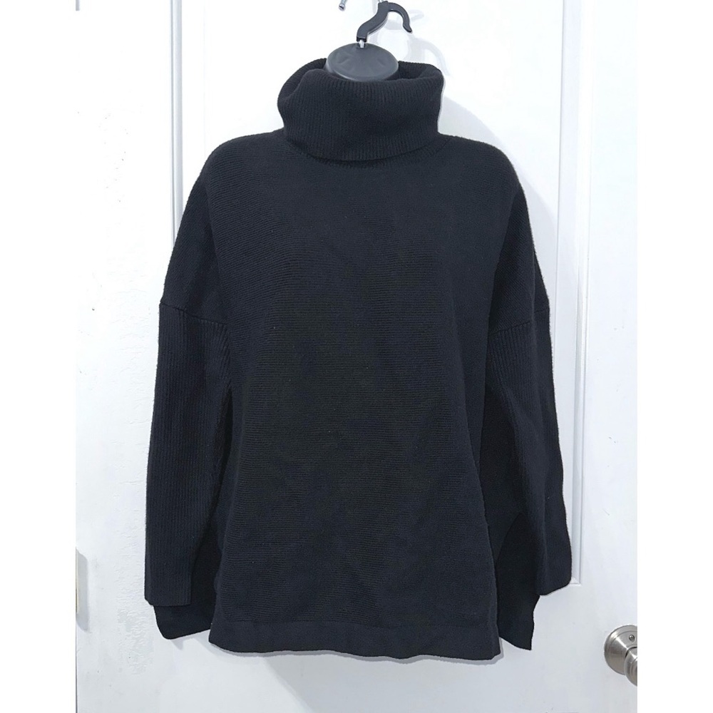 Black turtleneck sweater featuring a ribbed texture, dropped shoulders